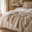 Dune Weave Winter Throw draped across a neutral bed